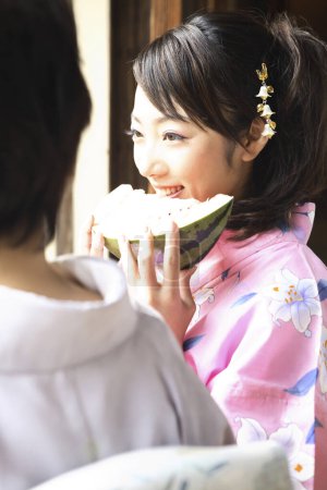 Photo for Close up view of beautiful japanese woman in kimono eating watermelon - Royalty Free Image