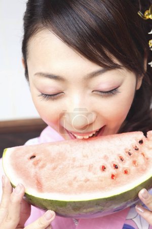 Photo for A woman eating a slice of watermelon - Royalty Free Image