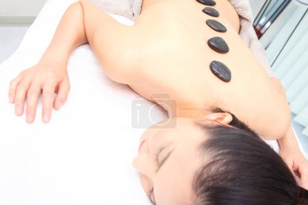 Photo for Asian woman relaxing on a hot stone massage - Royalty Free Image