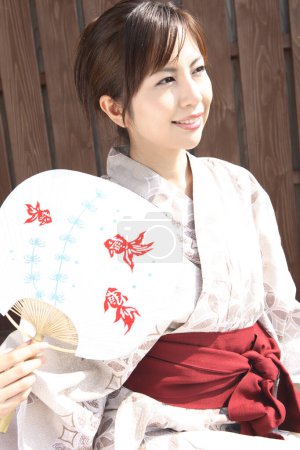 Téléchargez les photos : Une femme en kimono tenant un éventail - en image libre de droit