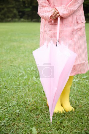 Téléchargez les photos : Une femme en manteau rose tenant un parapluie rose - en image libre de droit