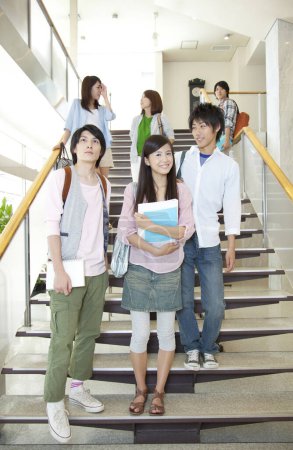 Foto de Retrato de estudiantes asiáticos de pie en las escaleras en el campus - Imagen libre de derechos