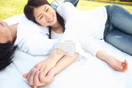 Photo for A couple laying on a blanket in the grass - Royalty Free Image