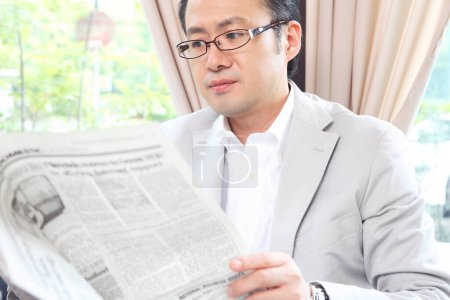 Foto de Un hombre leyendo un periódico en un restaurante - Imagen libre de derechos