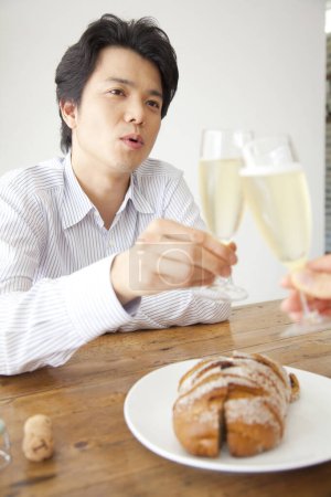 Téléchargez les photos : Jeune homme griller champagne avec femme à la maison - en image libre de droit