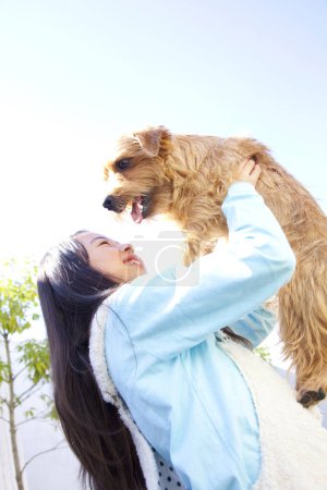 Téléchargez les photos : Mignonne petite fille asiatique avec elle Norfolk Terrier chien - en image libre de droit