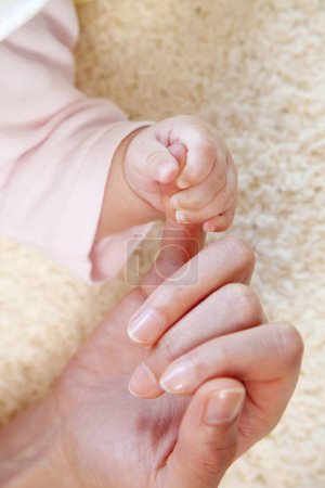 Photo for Baby hand holding a  finger of a mother. - Royalty Free Image