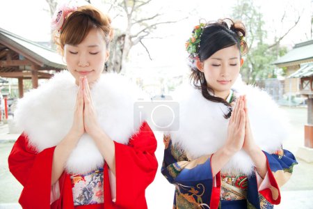 Téléchargez les photos : Portrait de belles femmes japonaises en vêtements traditionnels priant dans le sanctuaire - en image libre de droit