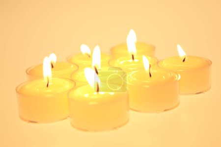 Photo for Many burning candles on yellow  background - Royalty Free Image