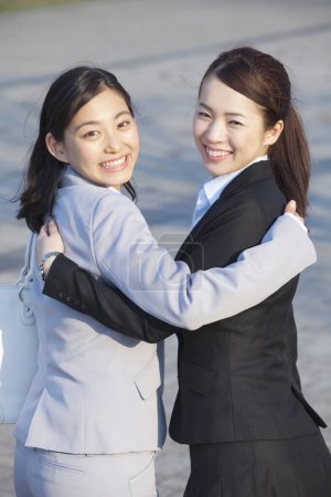 Photo for Two women in business clothes  hugging each other - Royalty Free Image