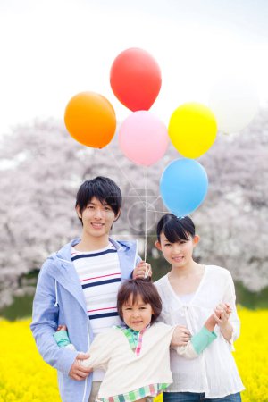 Photo for Portrait of happy Japanese family with colorful helium balloons - Royalty Free Image