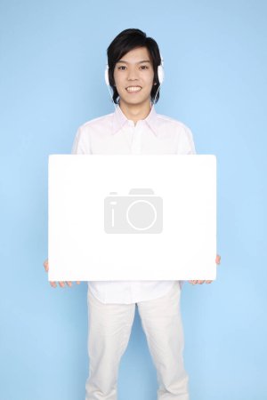 Photo for A man holding a sign in front of a blue background - Royalty Free Image