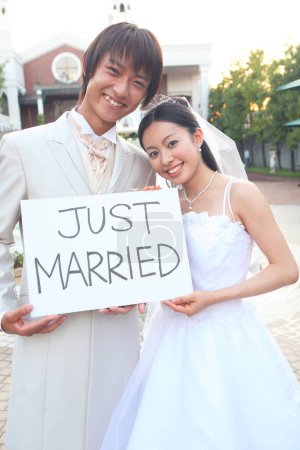 Téléchargez les photos : Beau couple heureux jeune mariage tenant la carte avec inscription juste marié - en image libre de droit