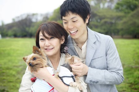 Téléchargez les photos : Un homme et une femme tenant des chiens dans un parc - en image libre de droit