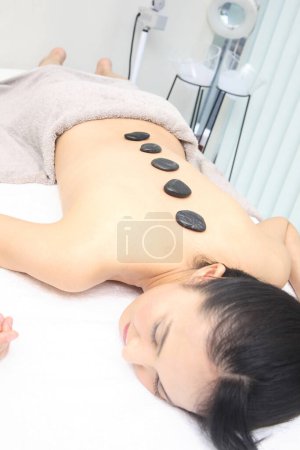 Photo for Asian woman relaxing on a hot stone massage - Royalty Free Image