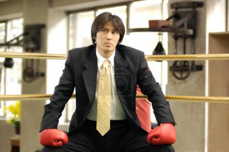 Photo for Young businessman with boxing gloves in gym - Royalty Free Image
