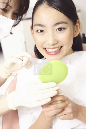 Photo for Young asian  woman getting her teeth treatment at dentist office - Royalty Free Image