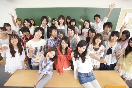 Foto de Grupo de estudiantes japoneses posando en clase cerca de pizarra - Imagen libre de derechos