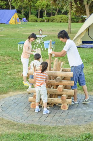 Téléchargez les photos : Heureux asiatique famille bâtiment cheminée ensemble - en image libre de droit