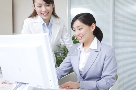 Téléchargez les photos : Portrait de belles femmes d'affaires japonaises travaillant avec ordinateur au bureau - en image libre de droit