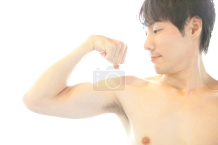 Téléchargez les photos : Asiatique jeune homme flexion biceps - en image libre de droit