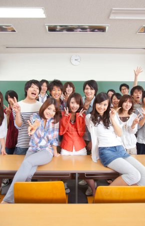 Foto de Grupo de estudiantes japoneses posando en clase cerca de pizarra - Imagen libre de derechos