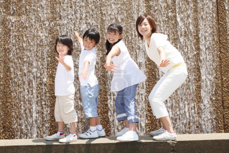 Photo for Japanese Mother and children joyful and in front of running water - Royalty Free Image