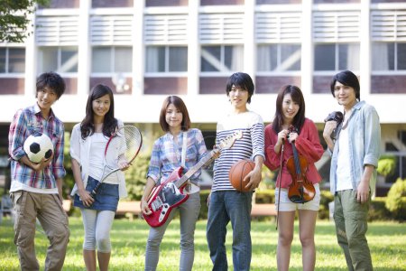 Téléchargez les photos : Heureux groupe d'étudiants de la musique et des sections sportives debout sur la pelouse verte - en image libre de droit