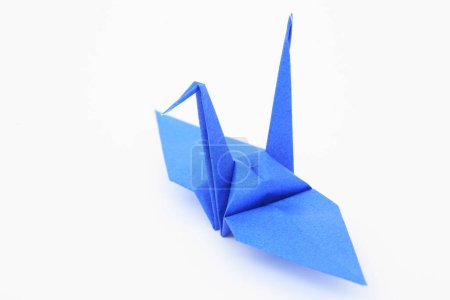 Foto de Grúa de origami de papel azul sobre fondo blanco - Imagen libre de derechos