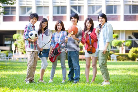 Téléchargez les photos : Heureux groupe d'étudiants des sections de musique et de sport près du campus bâtiment - en image libre de droit