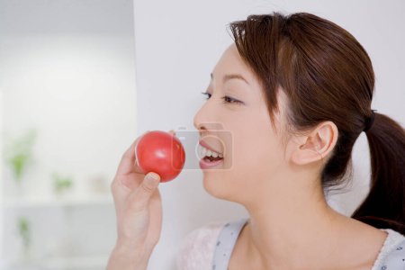 Téléchargez les photos : Portrait de belle asiatique femme tenant tomate rouge dans la main - en image libre de droit