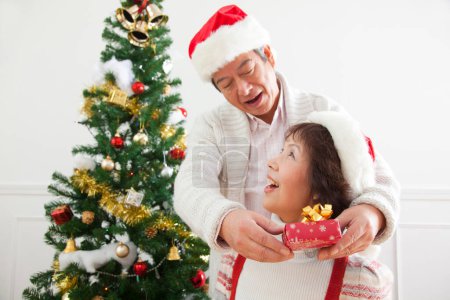 Photo for Asian senior man giving present to woman on  Christmas at home - Royalty Free Image