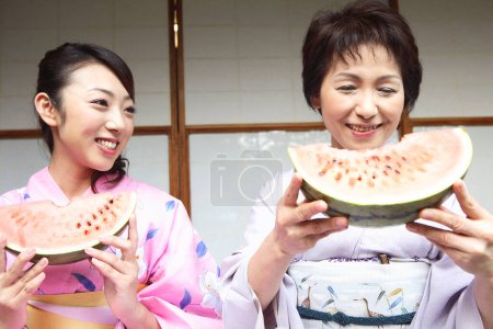 Photo for Close up view of beautiful japanese women in kimono eating watermelon - Royalty Free Image