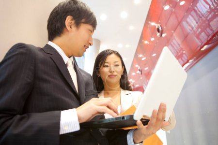 Téléchargez les photos : Asiatiques gens d'affaires avec ordinateur portable dans le bureau moderne - en image libre de droit