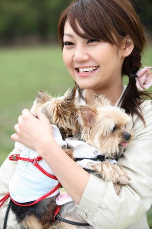 Téléchargez les photos : Une femme tenant un petit chien dans ses bras - en image libre de droit