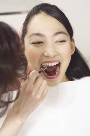 Foto de Joven asiático mujer llegar su dientes tratamiento en dentista oficina - Imagen libre de derechos