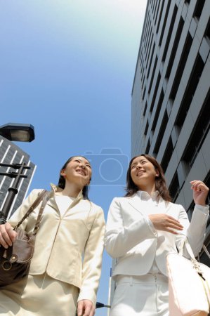 Photo for Two asian business women  walking in the city street - Royalty Free Image