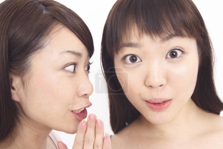 Photo for Asian woman sharing secret with friend - Royalty Free Image