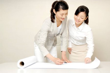 Photo for Asian women working with a blueprint - Royalty Free Image