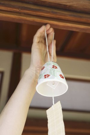 Téléchargez les photos : Vue rapprochée de la main féminine tenant le carillon japonais - en image libre de droit