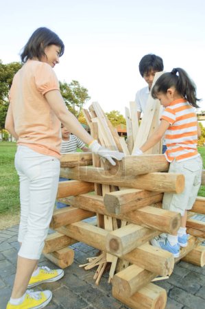 Téléchargez les photos : Heureux asiatique famille bâtiment cheminée ensemble - en image libre de droit