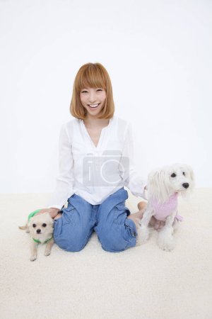 Photo for Beautiful asian woman with her dogs, studio shot - Royalty Free Image