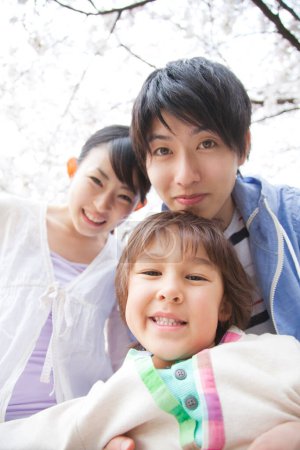 Foto de Retrato de la feliz familia japonesa en el parque de primavera - Imagen libre de derechos