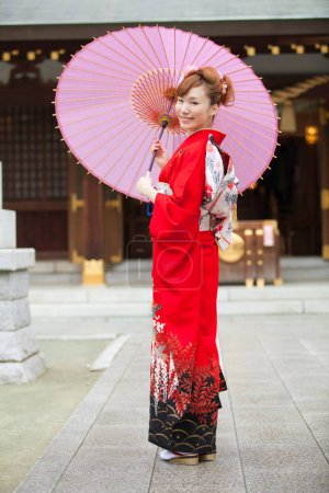 Foto de Hermosa japonesa joven mujer usando tradicional kimono celebración paraguas - Imagen libre de derechos