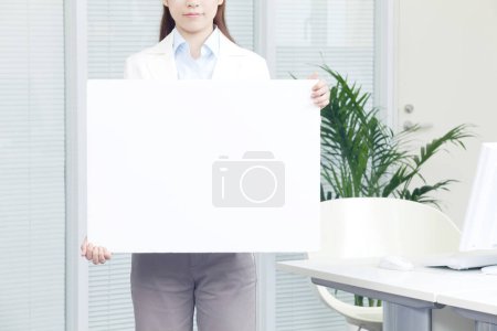 Foto de Retrato de mujer joven de pie en la oficina con tarjeta - Imagen libre de derechos