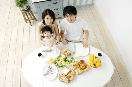 Photo for Young family with breakfast on kitchen - Royalty Free Image