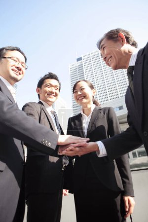 Foto de Asiático negocios personas con manos juntos al aire libre - Imagen libre de derechos