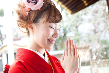 Foto de Retrato de la hermosa mujer japonesa en kimono rezando en el santuario - Imagen libre de derechos