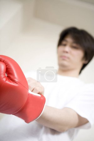 Photo for Asian male boxer in white shirt and red glove - Royalty Free Image