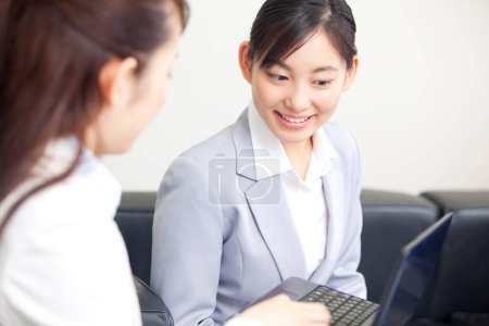 Photo for Two asian business women working on  a laptop - Royalty Free Image